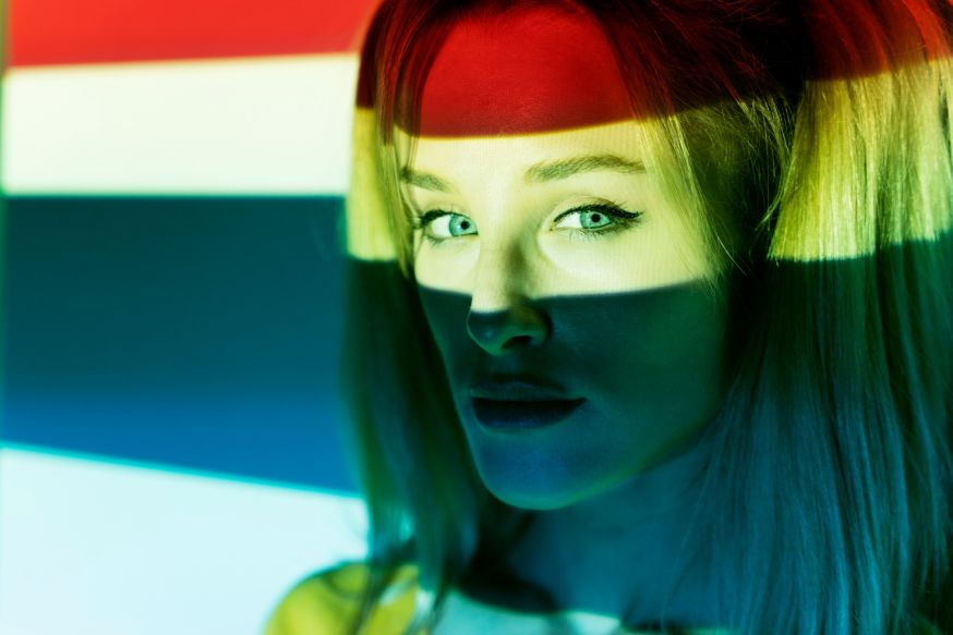 Afbeelding: Portret met grafische gekleurde lichtbanen op het gezicht ter illustratie van persoonlijke stijl