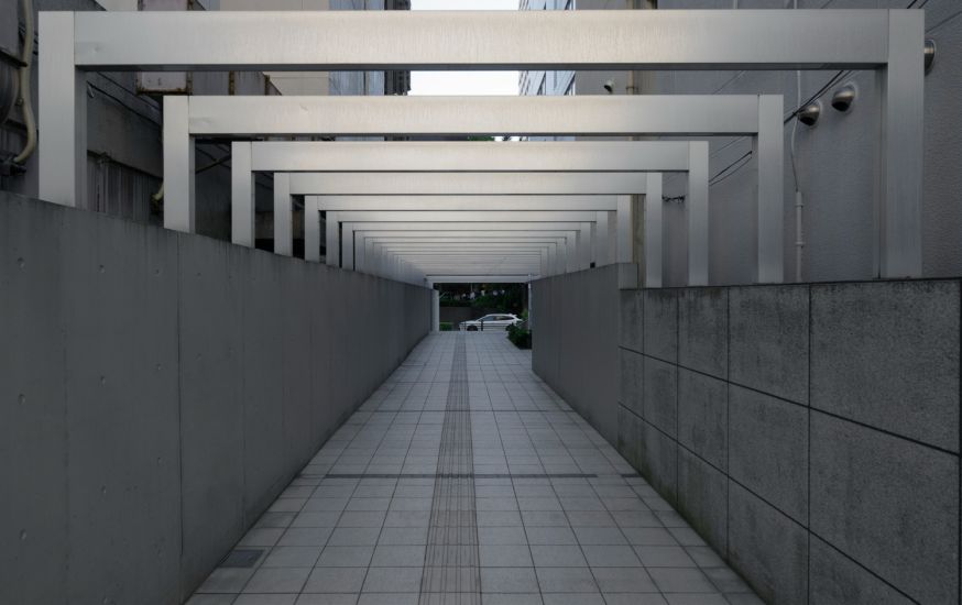 Afbeelding: Rechte doorgang met herhalende witte frames en een sterke middenlijn