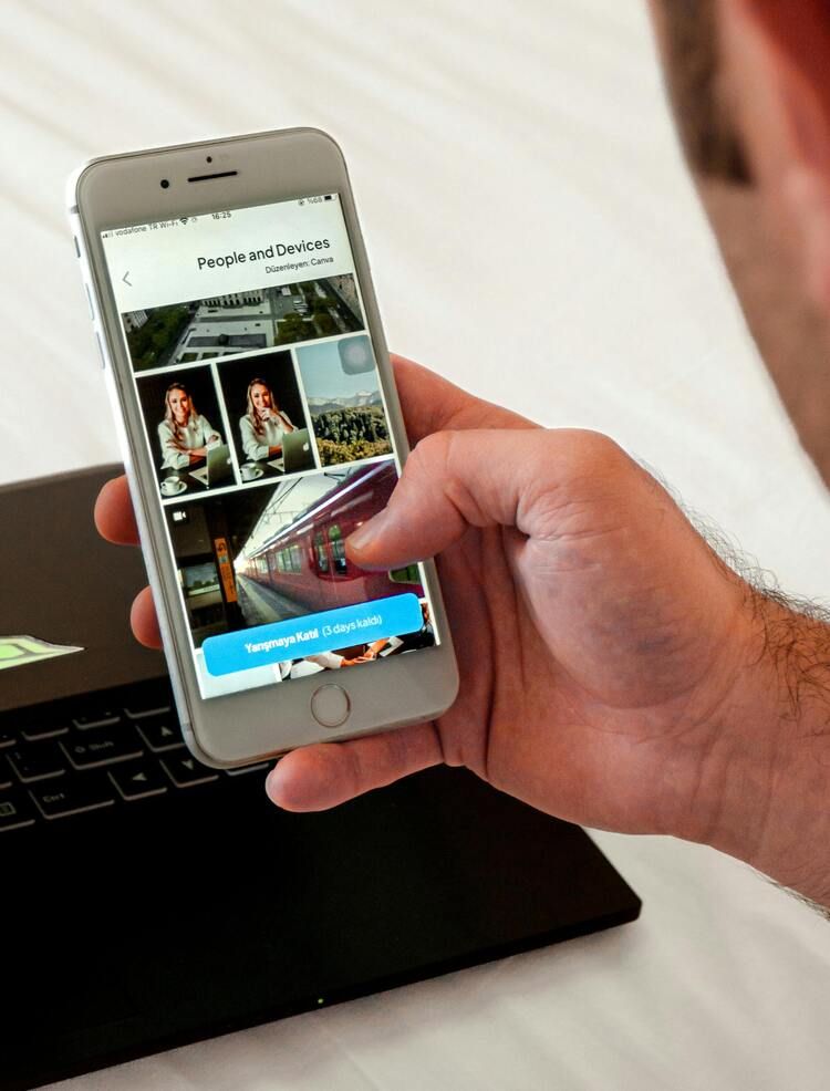 Afbeelding: Een close-up van een hand die een smartphone vasthoudt, waarop de mobiele downloadpagina van WeTransfer te zien is met een fotogalerij en een blauwe knop waarop de resterende tijd staat