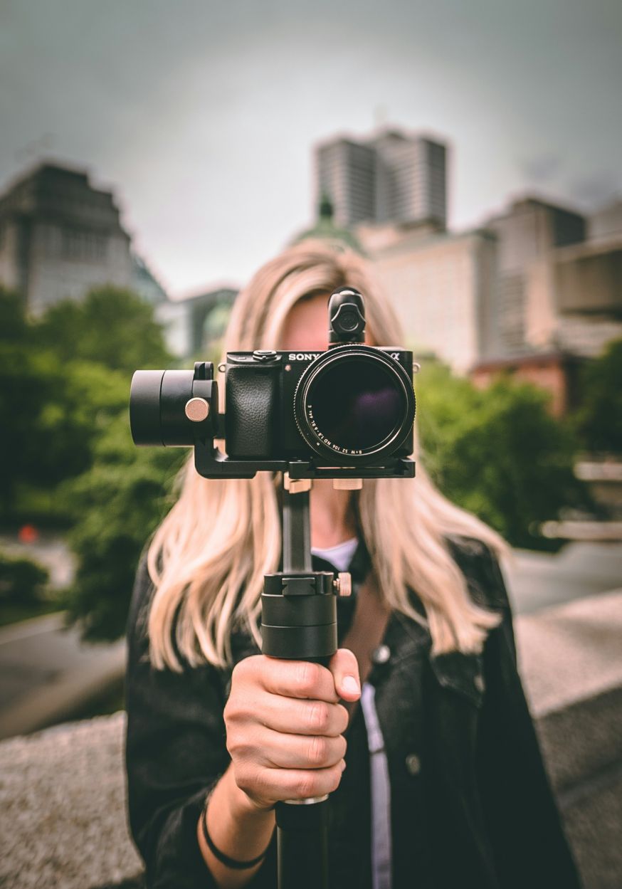 Afbeelding: Fotograaf met camera en ND-filter op de lens in stedelijke omgeving